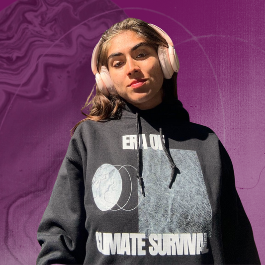 Person wearing the Climate Survival hoodie, with a textured purple background.